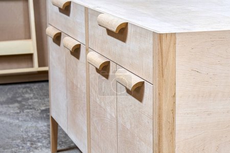 Chest of drawers made of solid alder in process of production at workshop close up view. Creation of modern domestic furniture for bedroom interior