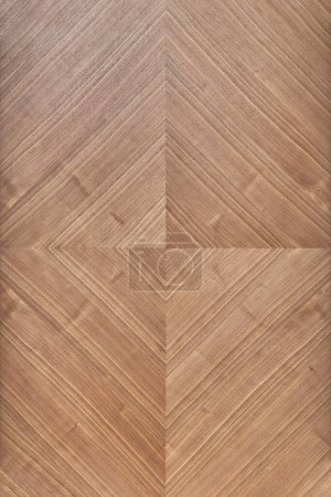 Wall panel of walnut veneer with geometric rhombic pattern as background. Natural materials for interior design. Stylish covering