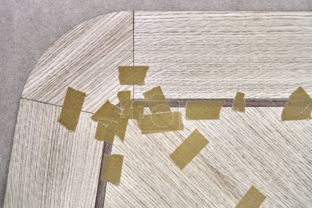 Chapa unida con cinta adhesiva en lona para la mesa de comedor con patrón geométrico en el banco de trabajo en la vista superior de cerca del taller