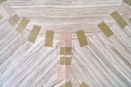 Jointed veneer with tape into canvas for table top of dining table with geometric pattern on workbench in workshop upper close view