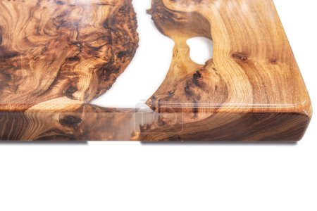 Borde vivo olmo burl mesa superior con resina epoxi central río sobre fondo blanco, la combinación de madera natural con un material sintético vista cercana