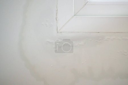 Téléchargez les photos : Mur de la maison près de la fenêtre avec de l'eau tache montrer peeling peinture - en image libre de droit