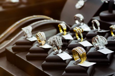 Téléchargez les photos : Bijoux bagues en diamant montrent dans la vitrine de la fenêtre du magasin de luxe - en image libre de droit