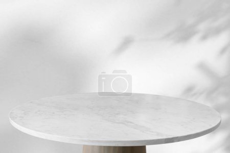 Foto de Mesa de mármol con caída de sombra de árbol en fondo de pared blanco para la exhibición de productos de maqueta - Imagen libre de derechos