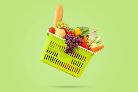 Frisches Obst und Gemüse Lebensmittelprodukt in grünem Warenkorb isoliert auf grünem Hintergrund