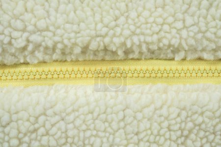 Téléchargez les photos : Fermeture éclair jaune sur laine peluche polaire tissu texture fond - en image libre de droit