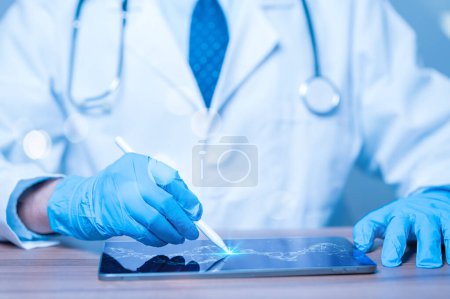 Ein Arzt benutzt ein Tablet, um auf einem Bildschirm zu schreiben. Die Tablette zeigt eine DNA-Sequenz an. Der Arzt trägt Handschuhe und einen weißen Laborkittel. Konzept der Professionalität und Konzentration auf wissenschaftliches Arbeiten