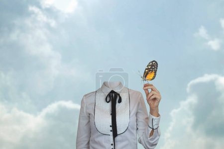 Foto de Mujer surrealista sin cabeza con una mariposa apoyada en su mano, concepto de fantasía y libertad - Imagen libre de derechos