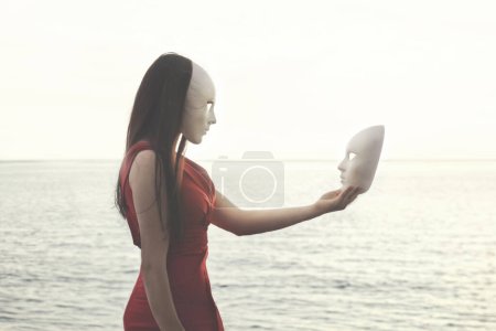 Téléchargez les photos : Moment surréaliste entre une femme avec le masque et un autre masque qu'elle tient, concept abstrait - en image libre de droit