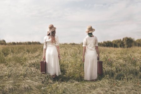 Foto de Dos viajeras surrealistas vestidas igual con maleta están listas para su viaje de aventura juntas, concepto abstracto - Imagen libre de derechos