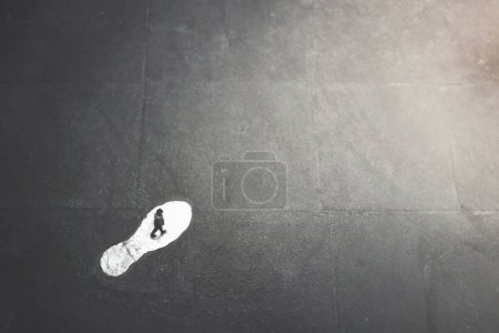 Téléchargez les photos : Homme suit le chemin d'une empreinte géante surréaliste sur la th - en image libre de droit