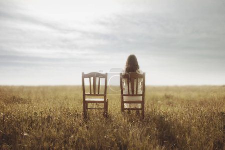 Foto de Mujer espera con dolor sentada junto a la silla vacía de su amante, concepto abstracto - Imagen libre de derechos