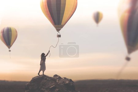 Téléchargez les photos : Femme tente d'attraper le fil descendant d'une montgolfière qui s'échappe librement dans le ciel, concept de voyage et d'aventure - en image libre de droit