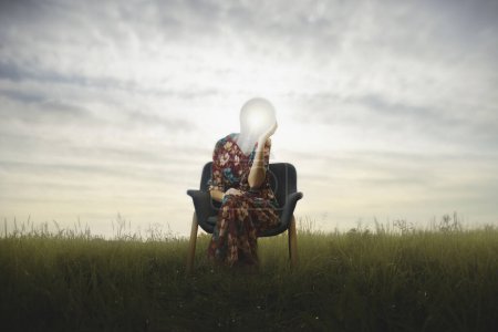 Photo for Surreal woman has a lit light bulb in place of her face, concept of creative idea and success - Royalty Free Image