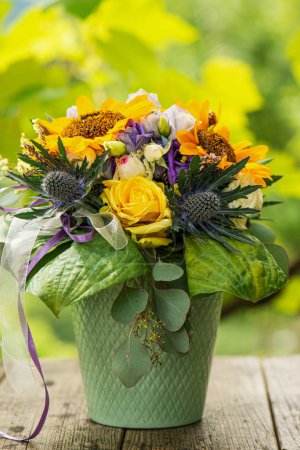 Téléchargez les photos : Bouquet de fleurs d'automne coloré dans une boîte en bois sur une table de jardin - en image libre de droit