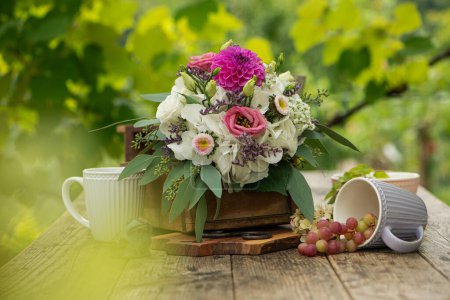 Photo for Summer flower bouquet on a wooden table with coffee cups - Royalty Free Image