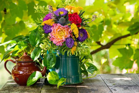 Téléchargez les photos : Bouquet de fleurs d'automne avec dahlia dans une théière en émail - en image libre de droit