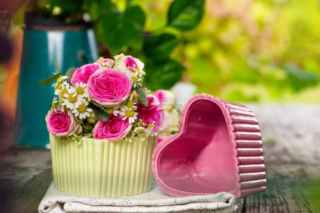 Téléchargez les photos : Petit bouquet de fleurs avec bols coeur sur table en bois - en image libre de droit