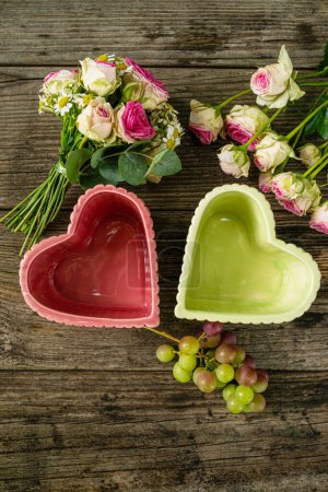 Téléchargez les photos : Petit bouquet de fleurs avec bols coeur sur table en bois - en image libre de droit