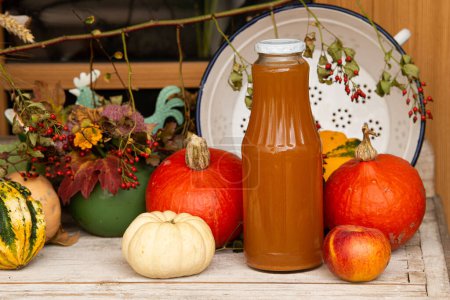 Téléchargez les photos : Jus de pomme maison dans une bouteille avec des fruits d'automne - en image libre de droit