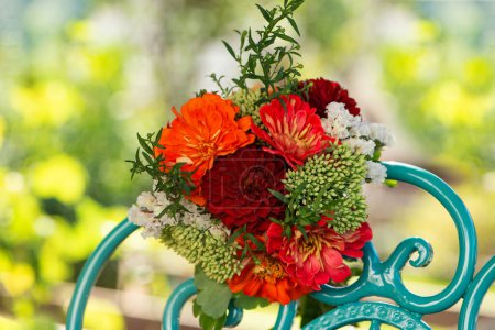 Foto de Colorido ramo de flores con dalias en una romántica silla de jardín con espacio para copiar - Imagen libre de derechos