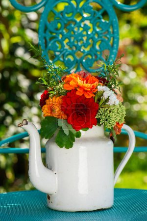 Foto de Colorido ramo de flores con dalias en una jarra de leche esmaltada con espacio para copiar - Imagen libre de derechos