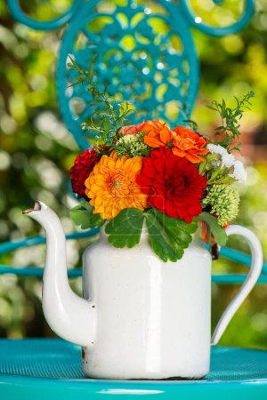 Téléchargez les photos : Bouquet de fleurs colorées avec des dalias dans une cruche à lait en émail avec espace de copie - en image libre de droit