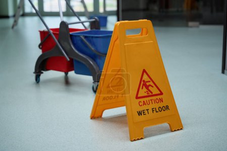 Photo for No people photo of a yellow caution sign placed on the wet floor after cleaning procedures - Royalty Free Image