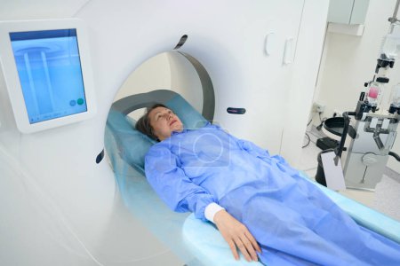 Foto de Woman undergoes a CT scan procedure in the diagnostic department of a hospital, she lies on a special mobile surface - Imagen libre de derechos