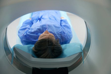 Foto de Patient was placed in the CT camera of the machine, she lies flat with outstretched arms - Imagen libre de derechos