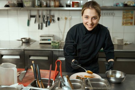 Foto de Mujer cocinar en el lugar de trabajo decora un plato con carne, ella cocinó la carne sous vide - Imagen libre de derechos