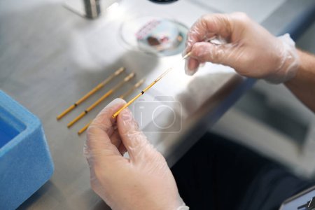 Photo for Female geneticist places a straw with an embryo in a chilled cap, next to a cuvette with liquid nitrogen - Royalty Free Image