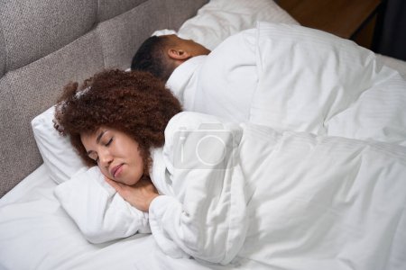 Foto de Guy y su novia duermen en la habitación del hotel, se alejaron el uno del otro, los chicos están ubicados en una cama grande - Imagen libre de derechos