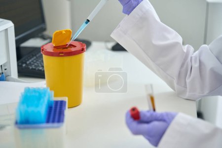 Foto de Empleado de un laboratorio clínico realiza una prueba de ADN, tiene una pipeta especial en sus manos - Imagen libre de derechos