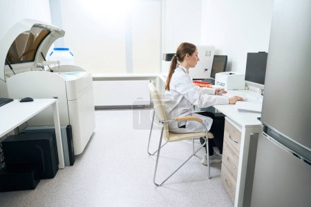 Photo for Woman scientist at the workplace in the diagnostic laboratory in the testing unit, modern equipment in the office - Royalty Free Image