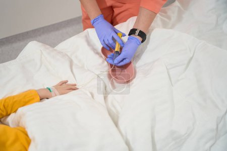 Foto de El retrato de cerca de las manos de los trabajadores médicos en guantes está preparando medicamentos para el paciente en la sala - Imagen libre de derechos