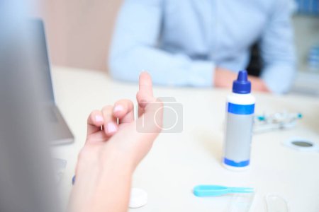 Photo for Close up picture of female fingers with lenses on it above the table - Royalty Free Image