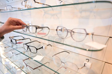Photo for Close up image of man hand is holding the optician frame in the modern shop - Royalty Free Image