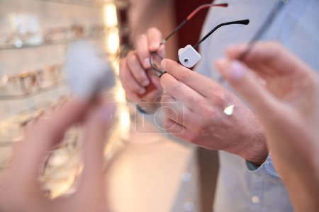 Photo for Side view portrait of unrecognized person is choosing the optician accessory for the gift in the store - Royalty Free Image