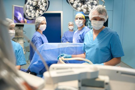 Foto de Anestesiólogo y un equipo de cirujanos trabajan con un paciente en el quirófano, equipo moderno en interiores - Imagen libre de derechos