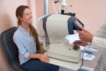 Photo for Waist up side view portrait of laughing female is getting qualified oculist consultation in modern ophthalmology center - Royalty Free Image