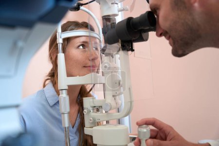 Photo for Close up portrait of female is getting qualified examining her eyes in the modern ophthalmology center - Royalty Free Image