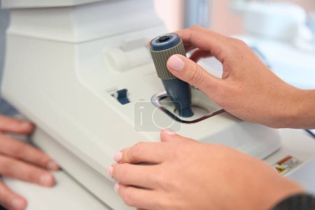 Photo for Close up image of qualified person is working with special optical machine in the ophthalmology center - Royalty Free Image