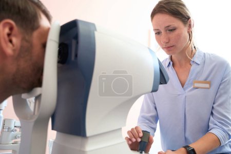 Photo for Close up side view portrait of beautiful Caucasian doctor is doing check up of eyesight in optician clinic - Royalty Free Image