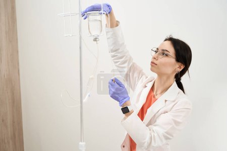 Foto de Retrato de la cintura hacia arriba de la hermosa enfermera caucásica está preparando la medicina para el paciente en el hospital - Imagen libre de derechos