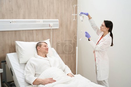 Foto de Retrato de vista lateral de longitud completa de hermosa doctora elegante está haciendo medicina para el paciente en el hospital moderno - Imagen libre de derechos