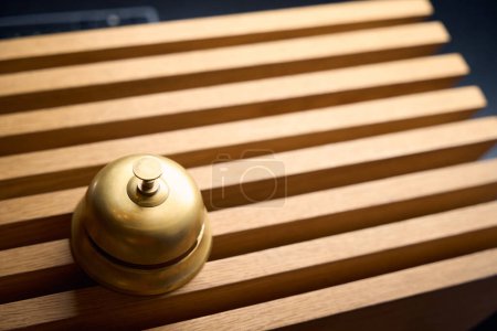 Téléchargez les photos : Cloche traditionnelle en cuivre pour appeler le personnel à la réception, petit bouton sur la cloche - en image libre de droit