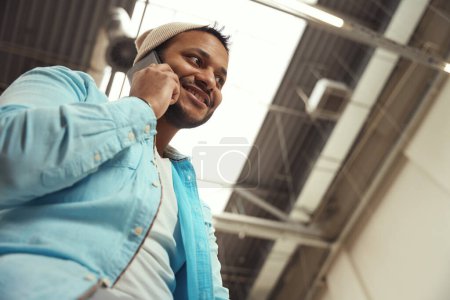 Téléchargez les photos : Photo rapprochée de jeunes hommes debout dans le bureau et appelant sur smartphone - en image libre de droit