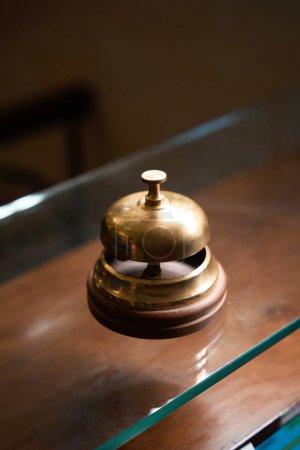 Téléchargez les photos : Photo rapprochée d'une vieille cloche de bureau en or sur une table en verre dans la zone de réception - en image libre de droit
