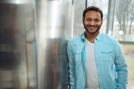 Téléchargez les photos : Portrait de l'homme souriant hindou en chemise bleue debout dans le bureau, prêt pour le travail - en image libre de droit